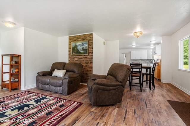 living area featuring baseboards, ornamental molding, and dark wood-style floors