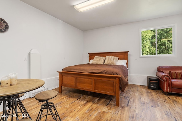 bedroom featuring baseboards and light wood finished floors