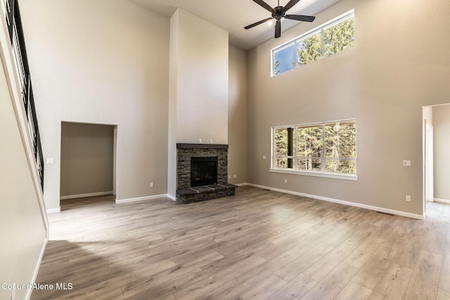 7587 E Duke Ln, Athol, ID 83801 - unfurnished living room featuring wood finished floors, baseboards, ceiling fan, and a high ceiling