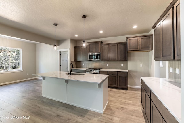 7587 E Duke Ln, Athol, ID 83801 - kitchen featuring decorative backsplash, a textured ceiling, range, a sink, and stainless steel microwave