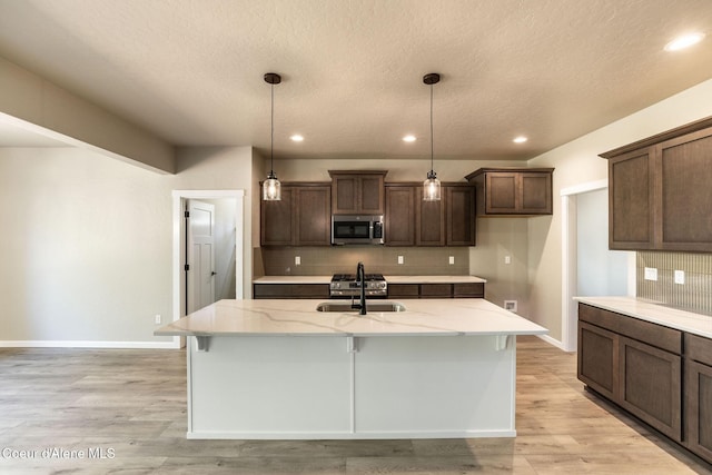 7587 E Duke Ln, Athol, ID 83801 - kitchen featuring tasteful backsplash, light stone countertops, a sink, baseboards, and stainless steel microwave