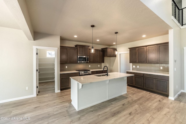 7587 E Duke Ln, Athol, ID 83801 - kitchen featuring a sink, light wood-style flooring, tasteful backsplash, and stainless steel appliances