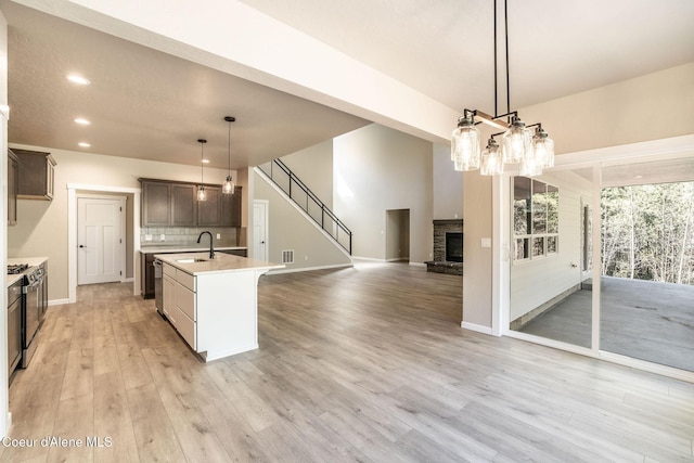7587 E Duke Ln, Athol, ID 83801 - kitchen featuring backsplash, a stone fireplace, a sink, light countertops, and open floor plan