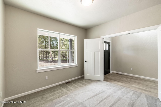 7587 E Duke Ln, Athol, ID 83801 - unfurnished bedroom with baseboards, carpet flooring, and visible vents