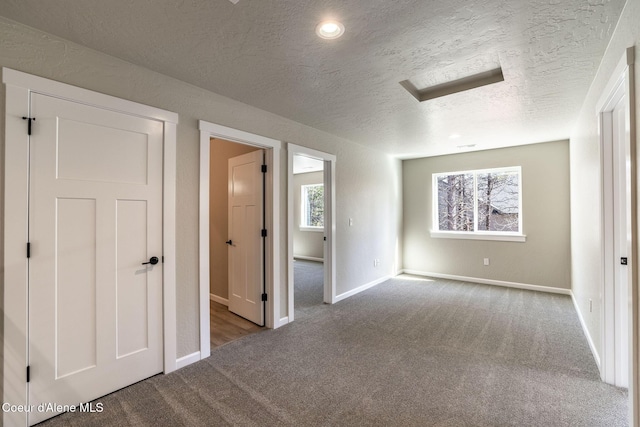 7587 E Duke Ln, Athol, ID 83801 - unfurnished bedroom featuring baseboards, carpet, and a textured ceiling