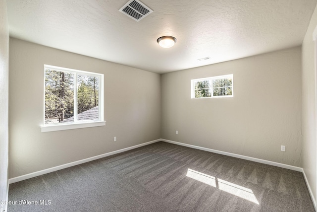 7587 E Duke Ln, Athol, ID 83801 - spare room with baseboards, dark colored carpet, and visible vents