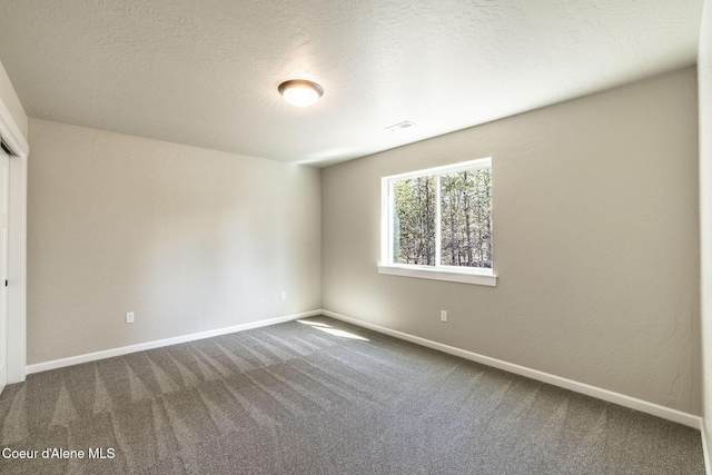 7587 E Duke Ln, Athol, ID 83801 - unfurnished bedroom featuring baseboards and dark carpet