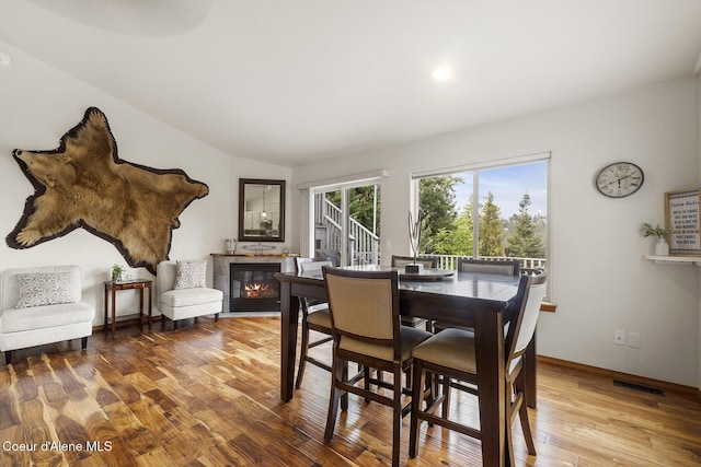 19820 S Alcan Rd, Coeur Dalene, ID 83814 - dining area with wood finished floors, a glass covered fireplace, baseboards, and lofted ceiling