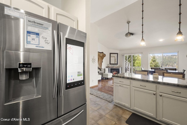 19820 S Alcan Rd, Coeur Dalene, ID 83814 - kitchen with stainless steel refrigerator with ice dispenser, tile patterned flooring, white cabinets, pendant lighting, and stone counters
