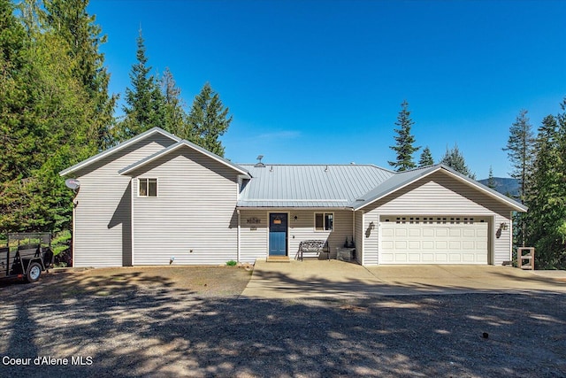 19820 S Alcan Rd, Coeur Dalene, ID 83814 - view of front facade with an attached garage, concrete driveway, and metal roof