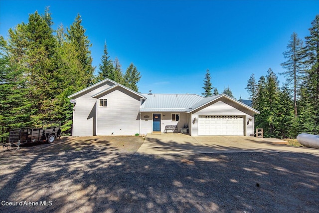 19820 S Alcan Rd, Coeur Dalene, ID 83814 - view of front of house with an attached garage, concrete driveway, and metal roof