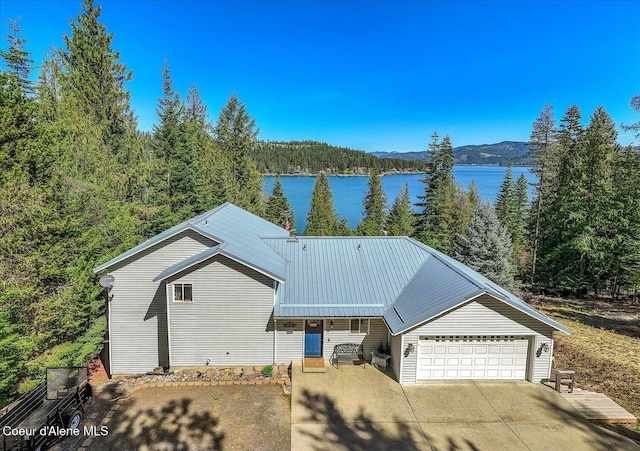 19820 S Alcan Rd, Coeur Dalene, ID 83814 - view of front of house featuring a view of trees, an attached garage, a water view, and driveway