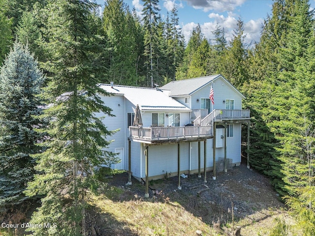 19820 S Alcan Rd, Coeur Dalene, ID 83814 - rear view of house featuring a forest view, a wooden deck, and metal roof
