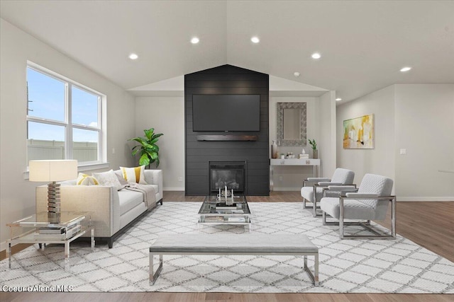living room featuring baseboards, recessed lighting, wood finished floors, and a fireplace
