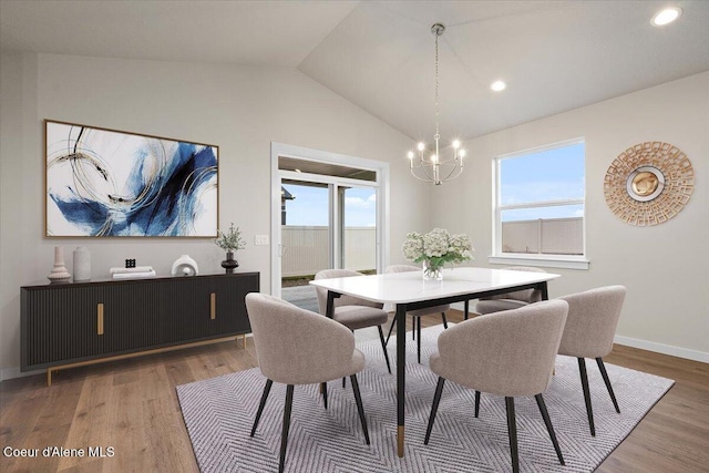 dining space with a notable chandelier, recessed lighting, baseboards, wood finished floors, and lofted ceiling