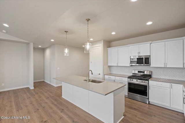 kitchen featuring backsplash, light wood-type flooring, a sink, stainless steel appliances, and recessed lighting