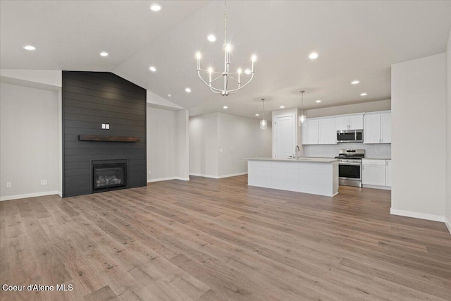 unfurnished living room with light wood-style floors, baseboards, recessed lighting, and a chandelier