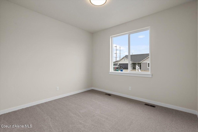 carpeted empty room featuring baseboards and visible vents