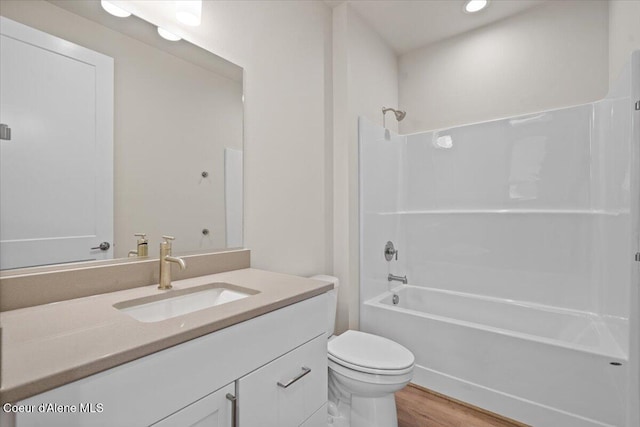 full bathroom with wood finished floors, vanity, toilet, bathing tub / shower combination, and recessed lighting