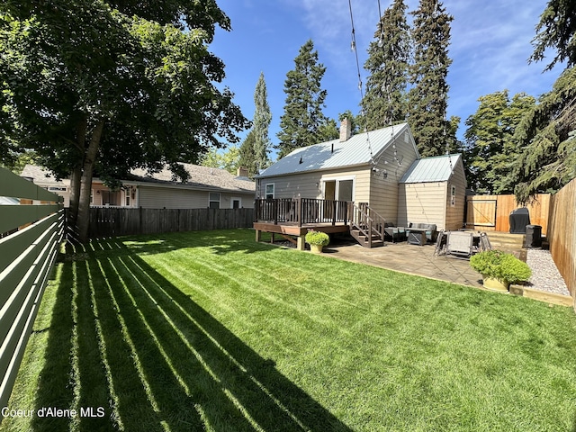 822 E Wallace Ave, Coeur Dalene, ID 83814 - rear view of house featuring a wooden deck, a fenced backyard, a lawn, a patio, and metal roof