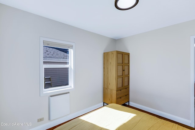 822 E Wallace Ave, Coeur Dalene, ID 83814 - unfurnished bedroom featuring baseboards, wood finished floors, and radiator