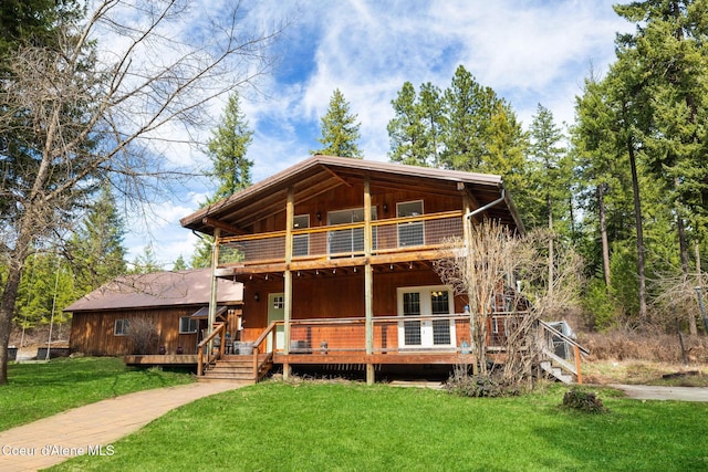log-style house featuring a front lawn, a balcony, and a deck