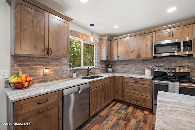 kitchen with decorative backsplash, pendant lighting, dark wood-style floors, a sink, and stainless steel appliances