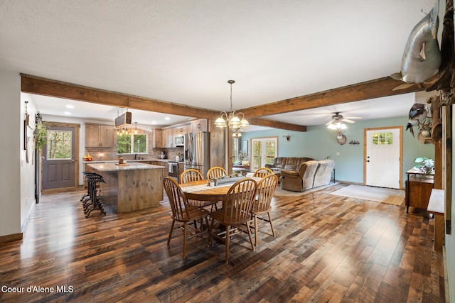 dining space with an inviting chandelier, dark wood-style floors, beam ceiling, and a healthy amount of sunlight