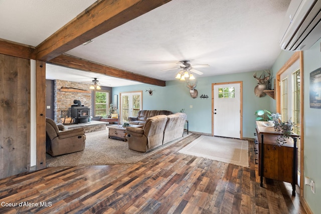 living room featuring ceiling fan, a wood stove, a wall mounted air conditioner, and wood finished floors