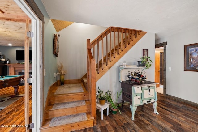 staircase featuring baseboards, wood finished floors, pool table, and a fireplace