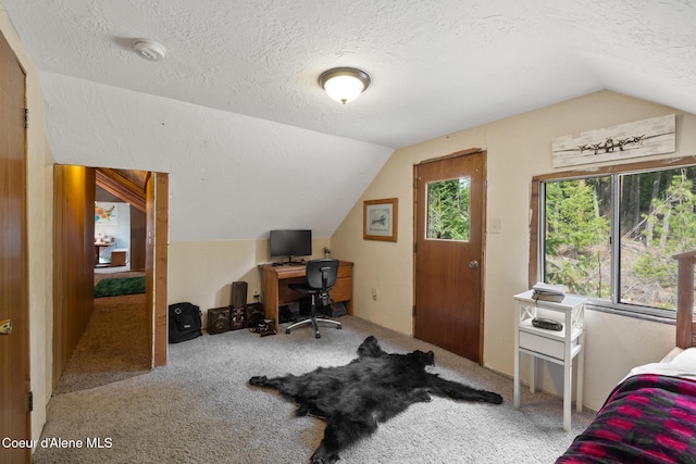 carpeted home office featuring a textured ceiling and lofted ceiling