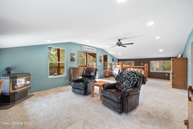 carpeted living area with recessed lighting, ceiling fan, lofted ceiling, and a wood stove