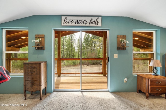 doorway to outside featuring carpet flooring, plenty of natural light, and lofted ceiling