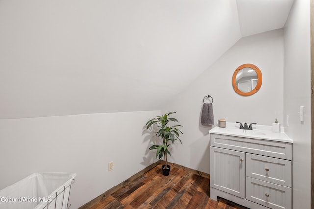 bathroom with vanity, wood finished floors, and vaulted ceiling