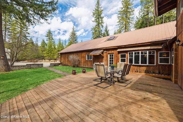 wooden terrace with a lawn and outdoor dining space