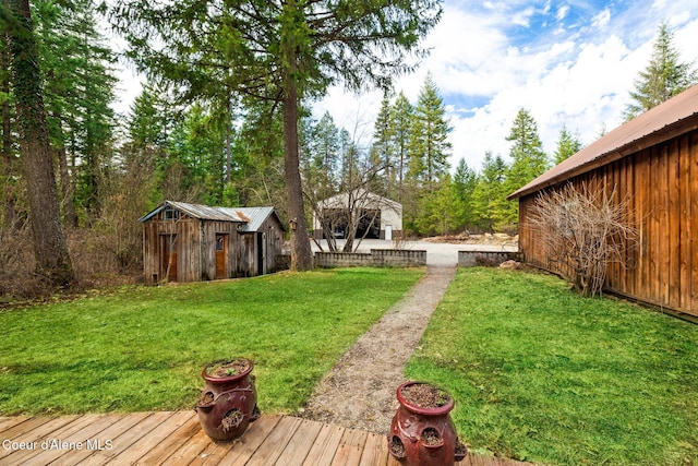 view of yard with an outdoor structure, a storage unit, and a deck
