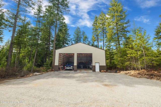 detached garage featuring a view of trees