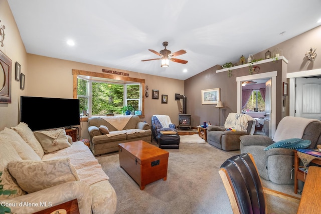 living room with carpet floors, a wood stove, recessed lighting, a ceiling fan, and vaulted ceiling