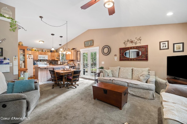 living room featuring french doors, vaulted ceiling, ceiling fan with notable chandelier, and light carpet