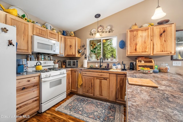 kitchen featuring pendant lighting, white appliances, dark wood-type flooring, a sink, and vaulted ceiling