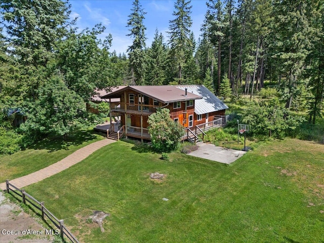 13168 N Clauson Trl, Rathdrum, ID 83858 - back of house featuring a deck, a wooded view, and a patio area