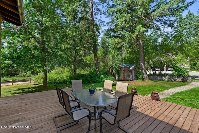 13168 N Clauson Trl, Rathdrum, ID 83858 - wooden deck featuring a storage unit, outdoor dining space, and a lawn