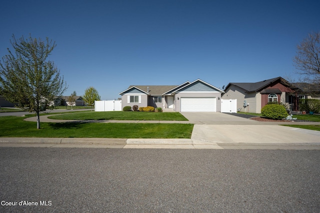 ranch-style home with a garage, fence, driveway, and a front yard