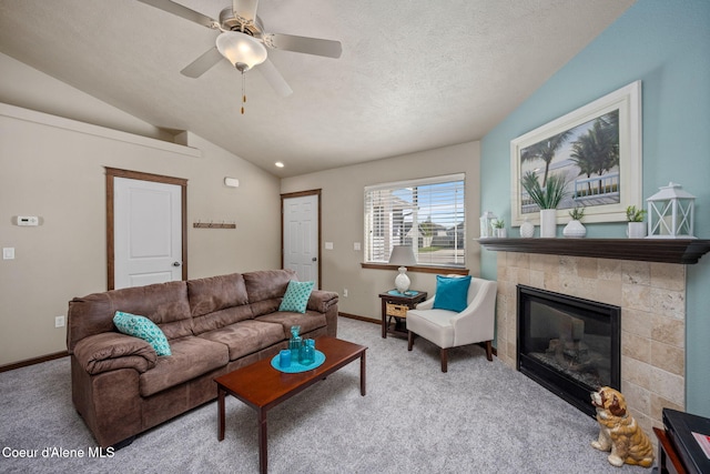 living room with baseboards, lofted ceiling, carpet, and a fireplace