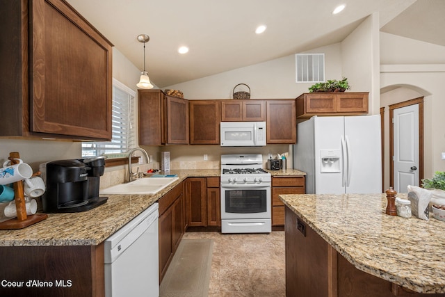 kitchen featuring visible vents, pendant lighting, lofted ceiling, white appliances, and a sink