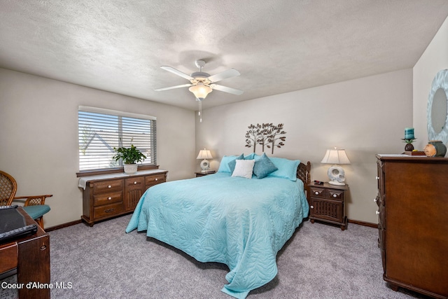 bedroom featuring a textured ceiling, baseboards, and light colored carpet
