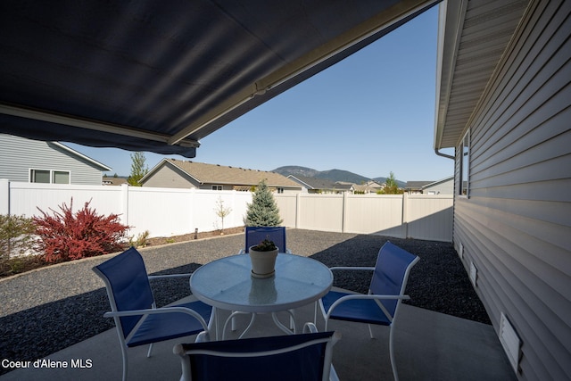 view of patio / terrace featuring a mountain view, a fenced backyard, and outdoor dining space