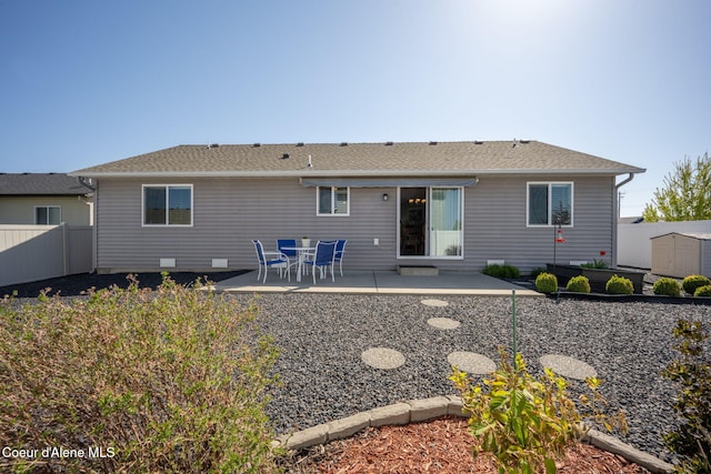 back of property with fence, a patio, an outdoor structure, and a storage shed