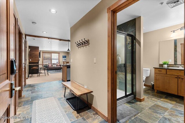 834 Mckinley Ave Unit 208, Kellogg, ID 83837 - full bath featuring stone tile floors, baseboards, a shower stall, toilet, and vanity