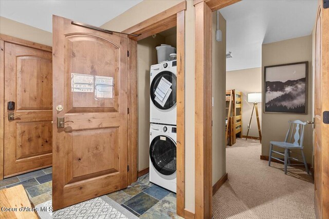834 Mckinley Ave Unit 208, Kellogg, ID 83837 - laundry area featuring stacked washer and clothes dryer, dark stone finish floors, and baseboards